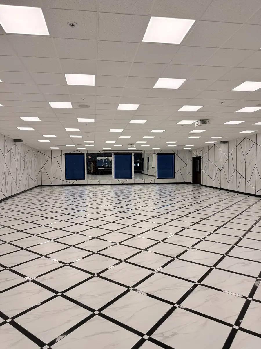 The empty main hall: marble-look walls with black geometric lines and a diamond-grid marble floor